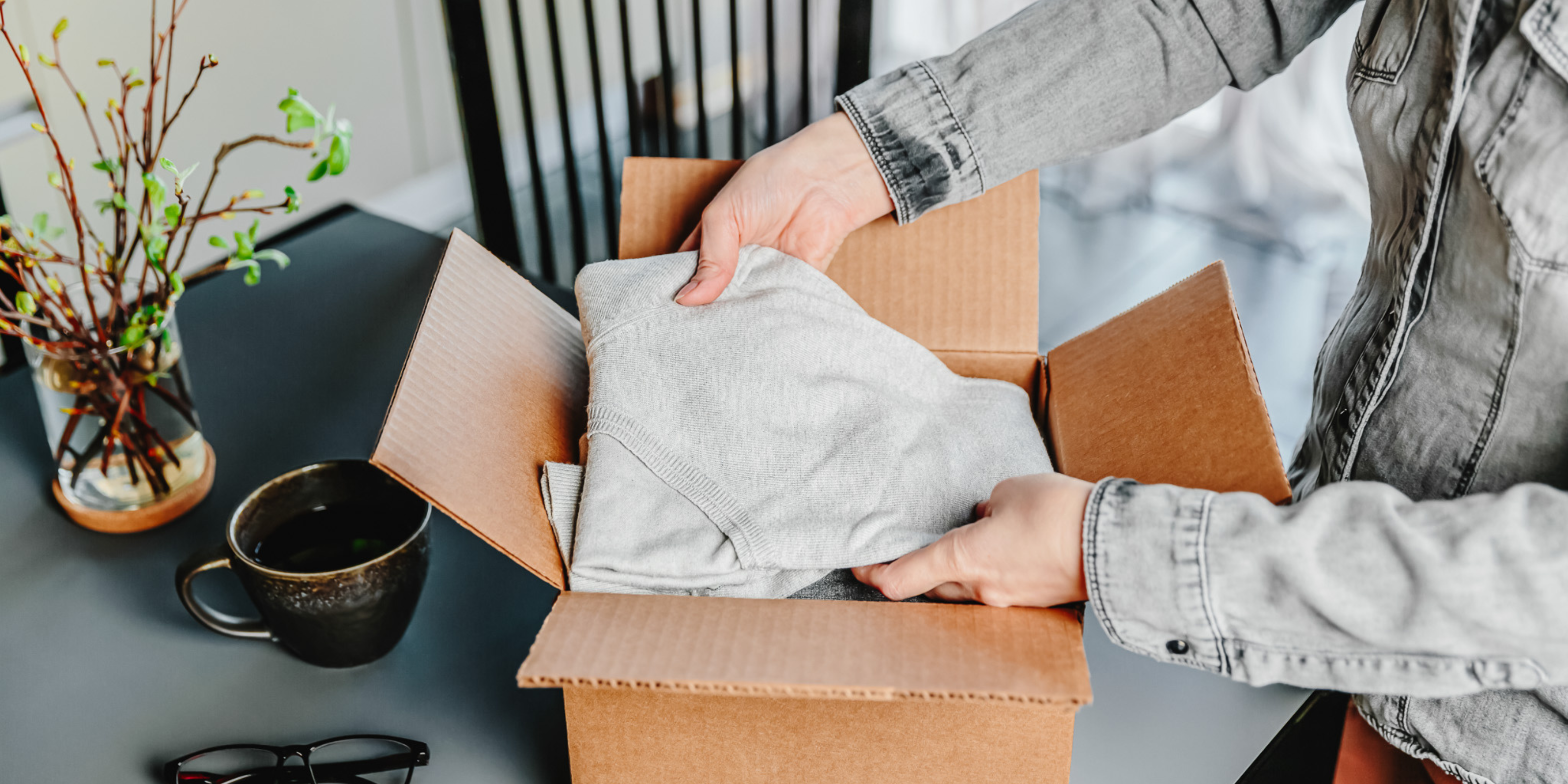 Clothing Reseller packing clothes into a box.